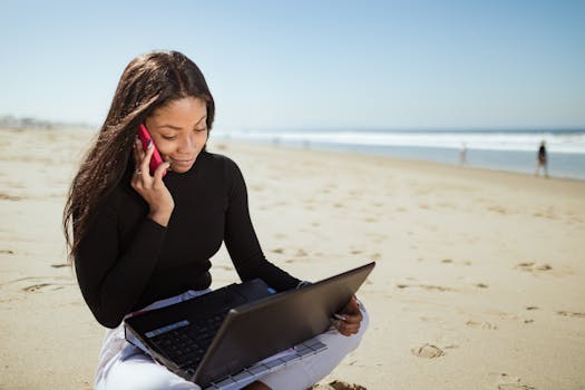 digital nomad working on laptop at a beach